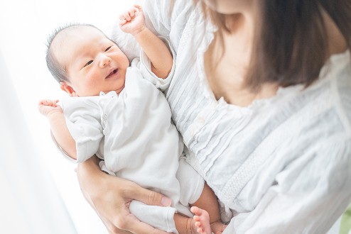 新生児を抱っこしている女性の写真