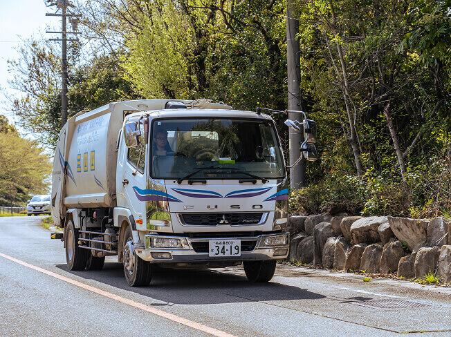 道路を走るごみ収集車の写真
