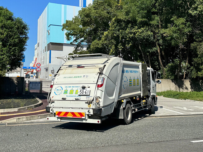道路を走るごみ収集車の写真
