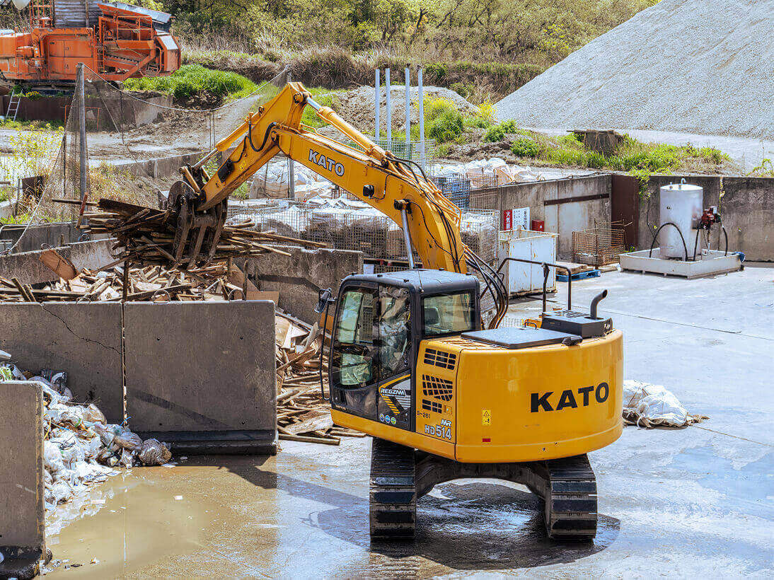 ショベルカーで産業廃棄物を掴んでいる写真