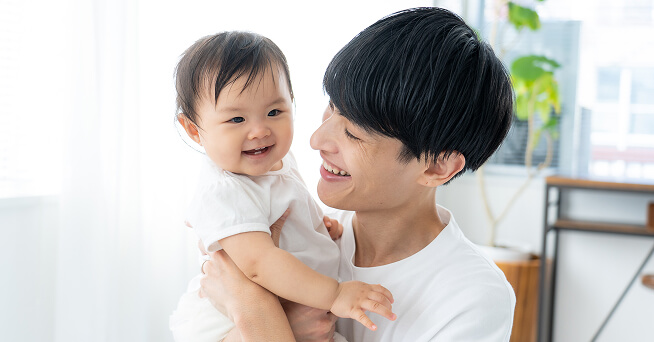 赤子を抱っこしている男性の写真