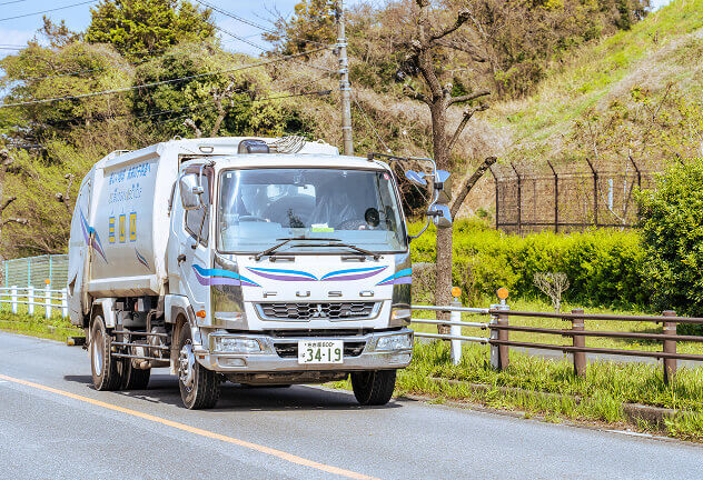 道路を走っているごみ収集車の写真