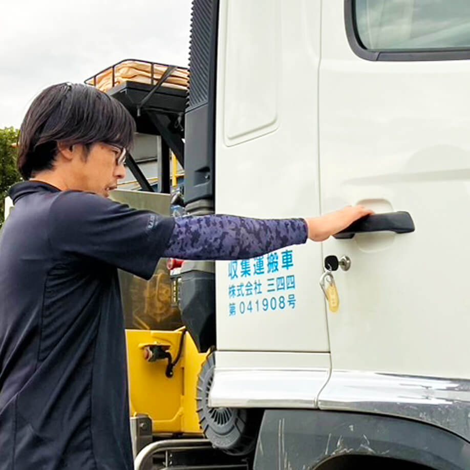 ドライバーの男性が収集車の運転席に乗ろうとしている写真