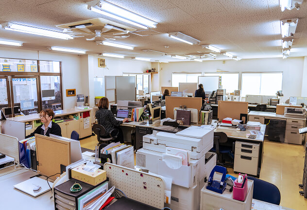 事務所内で社員が事務作業している写真
